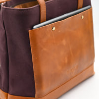 Brown leather and fabric bag with a tablet pocket on a white background