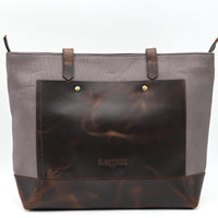 Gray tote bag with brown leather accents on a white background