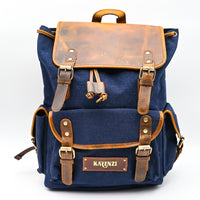 Blue backpack with brown leather straps and accents on a white background