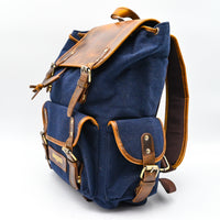 Blue backpack with brown leather accents on a white background