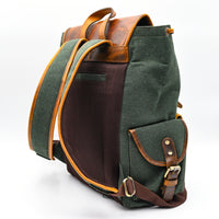 Green backpack with brown leather accents on a white background