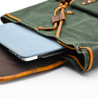 Green leather bag with a blue laptop inside on a white background