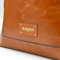 Brown leather bag with 'KARENZI' brand label on a white background