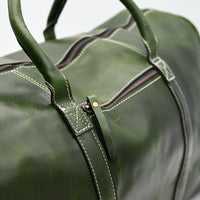 Green leather duffel bag on a light gray background