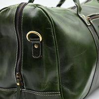 Green leather duffel bag with gold hardware on a white background