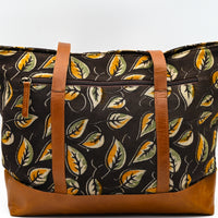 Bag with leaf pattern and brown straps on a white background