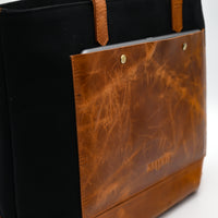 Black and brown leather bag with 'KATIE' branding on a white background