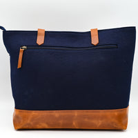 Navy blue bag with brown leather accents on a white background