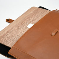 Brown leather and wood-patterned laptop sleeve on a white background
