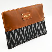 laptop pouch with brown leather top and black and white patterned bottom on a white background