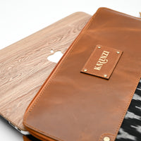Brown leather case with 'KARENZI' branding on a wooden surface