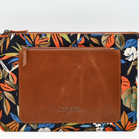 Floral-patterned pouch with brown leather flap on a white background