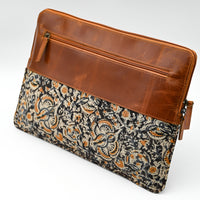 Patterned pouch with brown leather trim on a white background