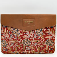 Floral-patterned pouch with brown leather flap on a white background