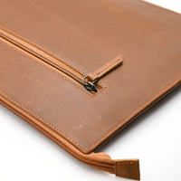 Brown leather pouch with zipper on a white background